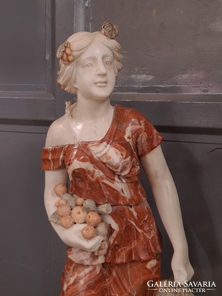 Antique marble sculpture woman figure holding bunch of grapes, wine, vintage representation