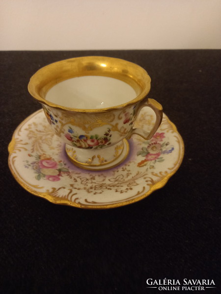 Barokk formavilágú, dúsan díszített, aranyozott szegélyű porcelán csésze alátéttel.