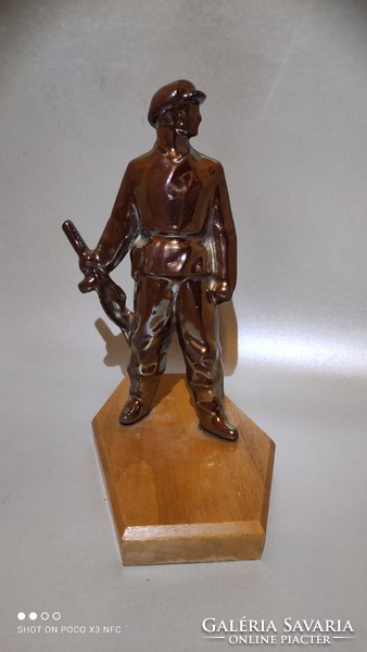 Vintage retro eosin glazed metal laborer statue on wooden sole