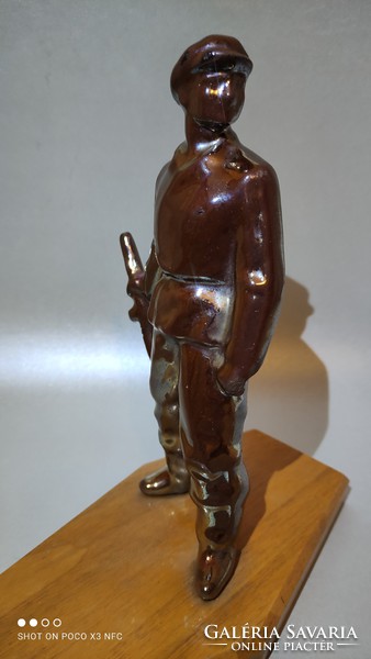 Vintage retro eosin glazed metal laborer statue on wooden sole