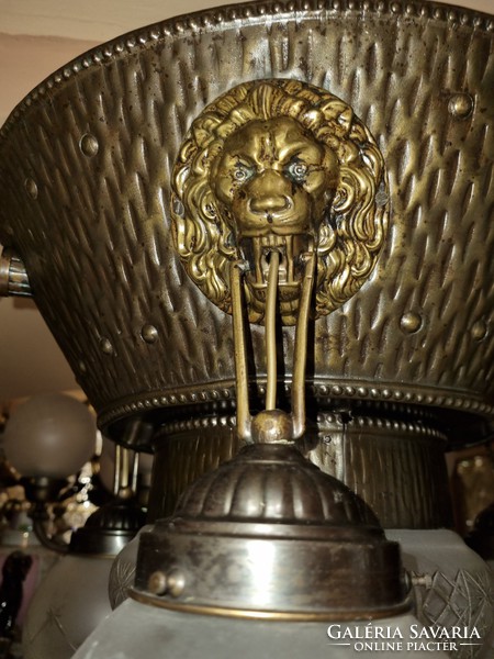 Old renovated lion head with crystal shrouded copper chandelier