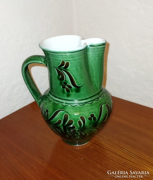 Folk green ceramic jug pouring