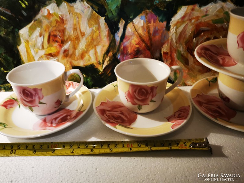 Four rosy porcelain teacups and placemats