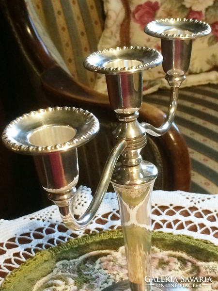 Silver-plated, flower-decorated, three-pronged candle holder to enhance the festive atmosphere.