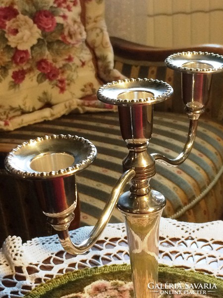 Silver-plated, flower-decorated, three-pronged candle holder to enhance the festive atmosphere.