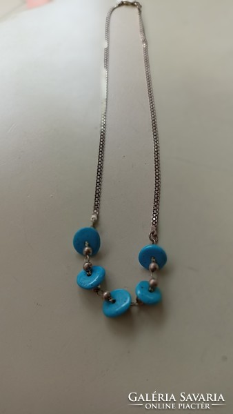 Silver necklace decorated with real turquoise discs in blue.
