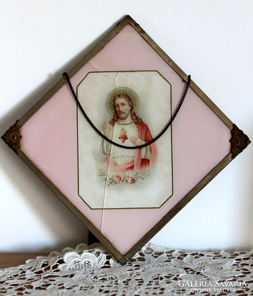 Antique holy image, hanging on the wall, in a metal frame, under a glass plate