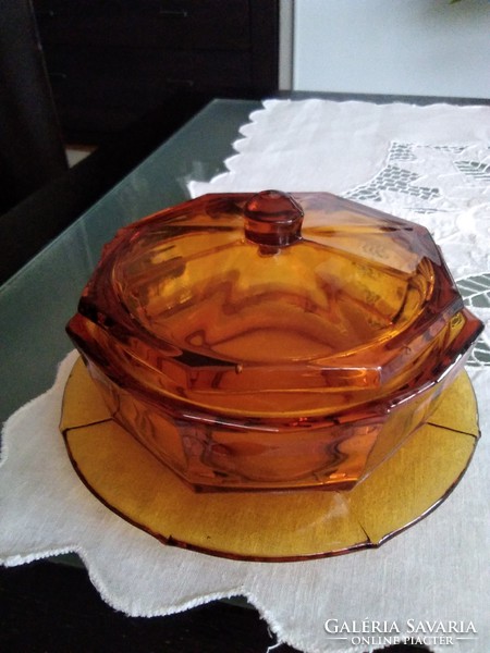 Amber octagonal glass butter holder with two wavy edges, together.