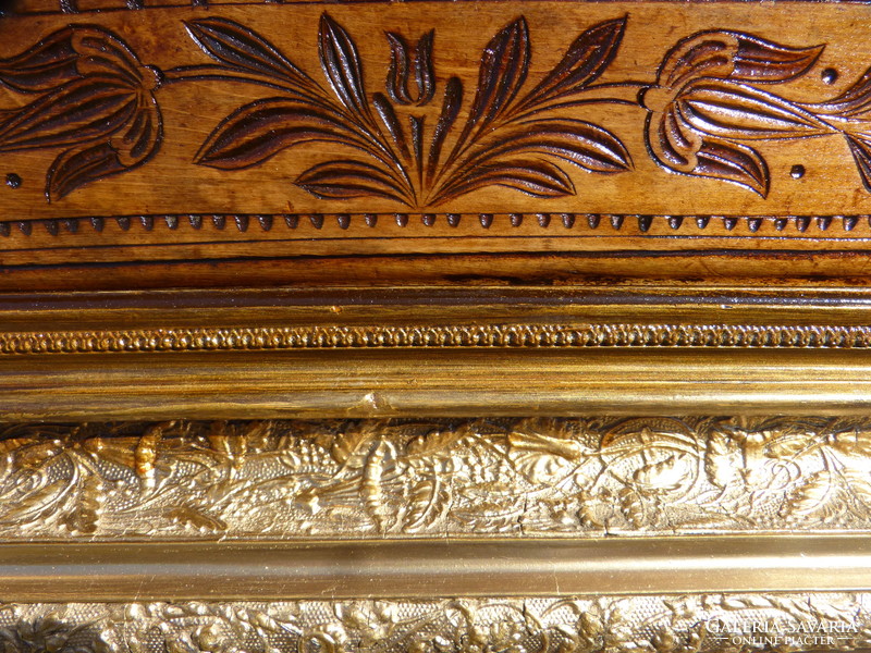 Folk wood carving in gilded picture frame.