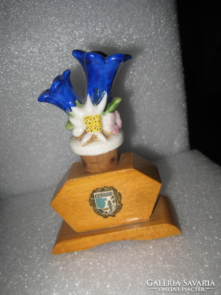Old porcelain drink spout in a wooden holder with the two most beautiful alpine flowers on it, the ......