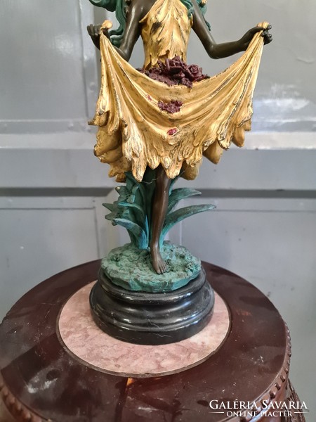 Bronze statue of young woman painted with flowers