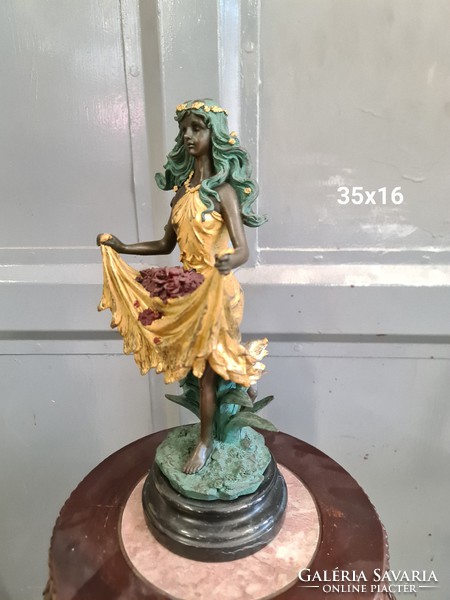 Bronze statue of young woman painted with flowers