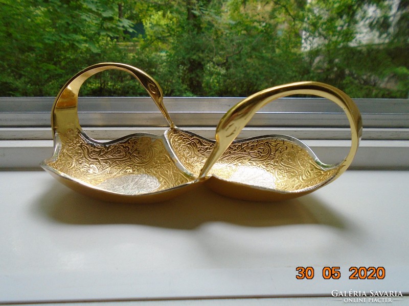 Handmade table centerpiece with a pair of gilded plastic swans, detailed relief patterns