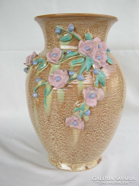 A large vase decorated with hoppy ceramic flowers