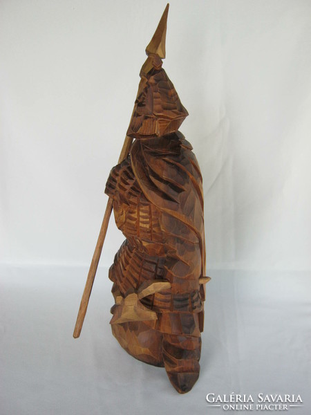 Wooden statue of a Viking warrior carved with a spear and an ax