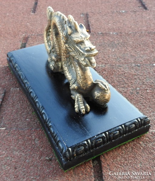 Old oriental bronze dragon on a wooden base