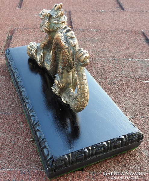 Old oriental bronze dragon on a wooden base