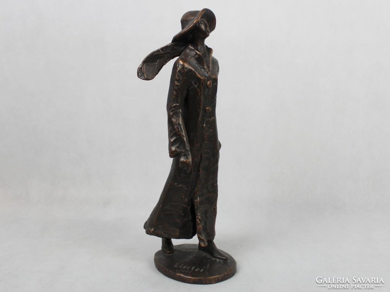 Statue of a woman in a hat with a bronze rose