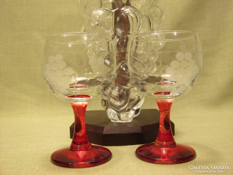 Bottle of wine set with bunch of grapes in a bottle and 2 goblets on a stand