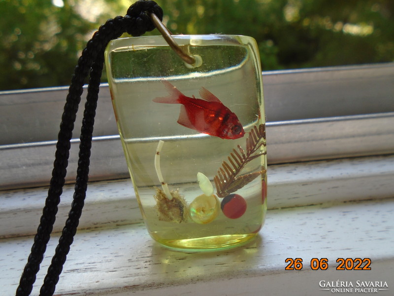 Aquatic life enclosed in a large pendant with a red fish, lace