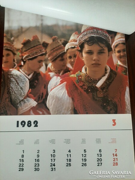 Wall calendar from 1982 showing Hungarian folk costumes by landscape