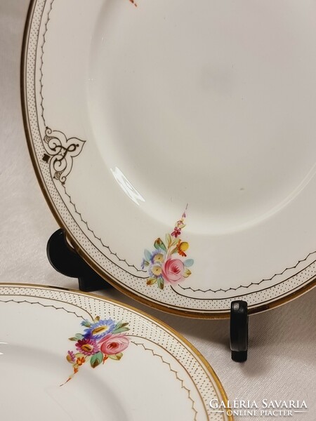 2 Tielsch display case gold-painted porcelain cookie plates with floral patterns.