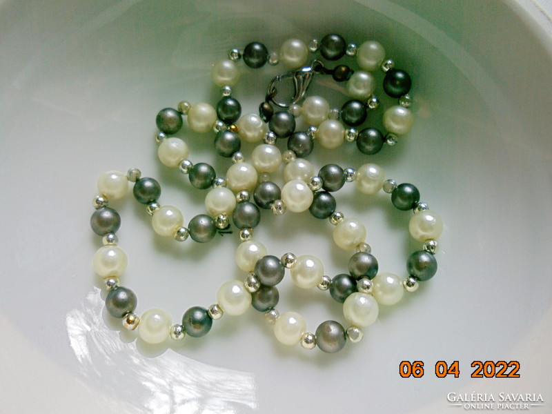 Necklaces made of shiny grayish black mineral, saltwater pearls and gold-colored intermediate pearls