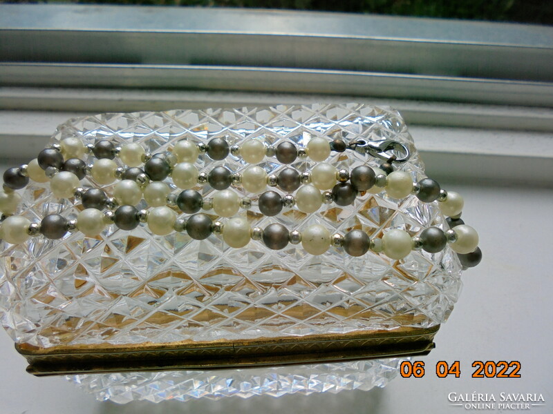 Necklaces made of shiny grayish black mineral, saltwater pearls and gold-colored intermediate pearls