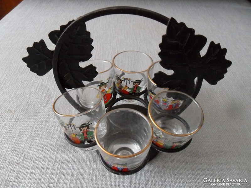 Retro cognac set in an iron holder with fun glasses in folk costume