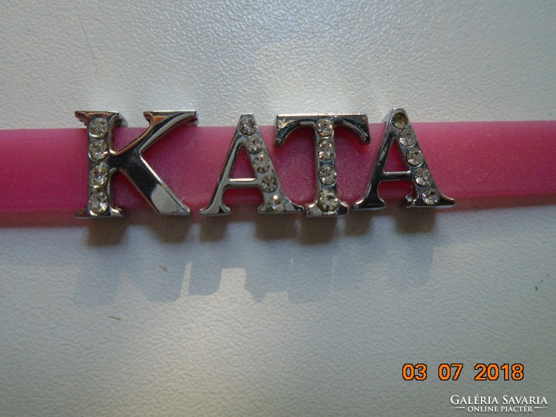 Modern rózsaszínű csukló pánt KATA  ezüstözött, kövekkel kirakott betűkkel díszítve