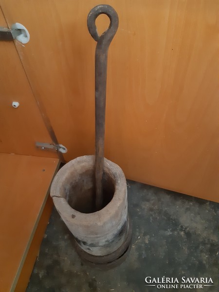 Old wooden mortar with tires, with an iron pestle