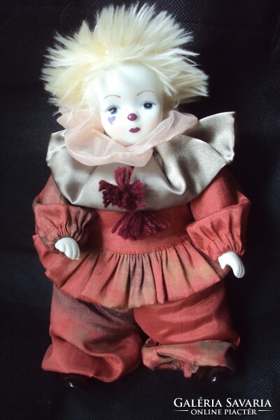 A cute little chubby clown with a porcelain head and limbs, a tufted hat, and a beautiful silk dress.