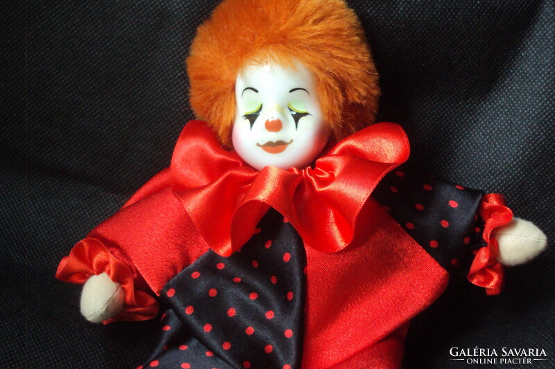 Antique clown doll with porcelain head, red hair, in new clothes.