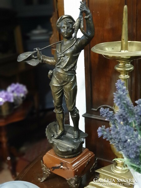 Statue of a fishing boy on a marble plinth