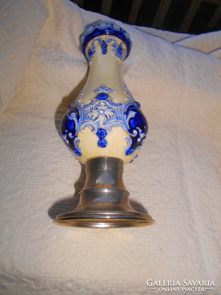 An antique majolica vase with a metal base