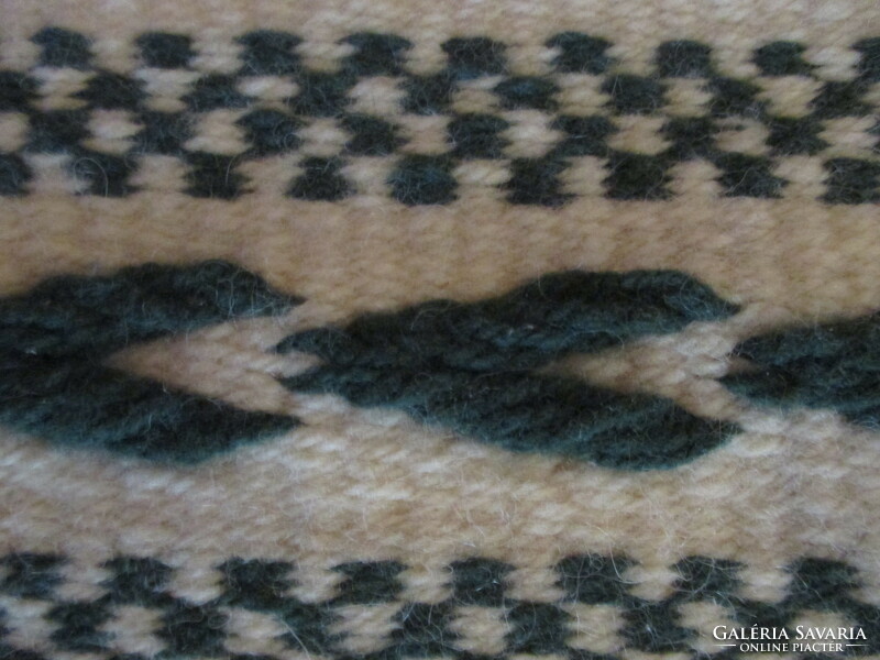 Small wool rug, green pattern on a raw base