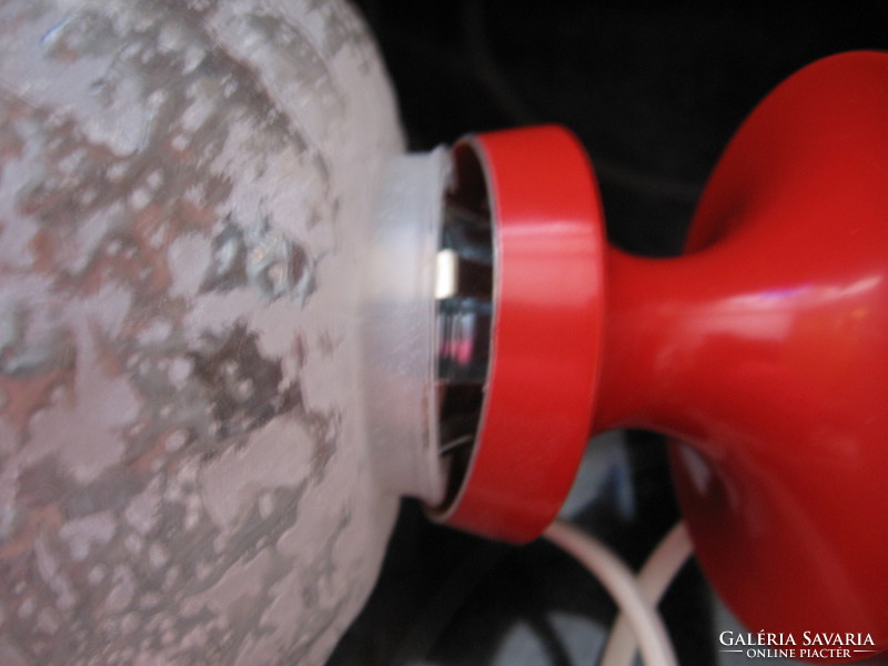 Retro space age lamp with a red metal base and a clear glass sphere