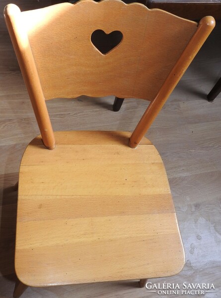 Old wooden children's small chair with heart decor on the headrest