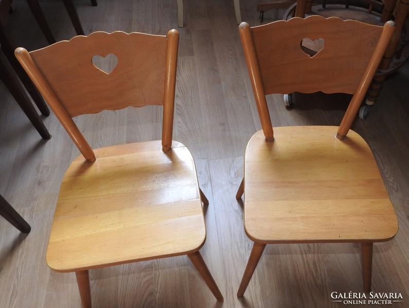 Old wooden children's small chair with heart decor on the headrest