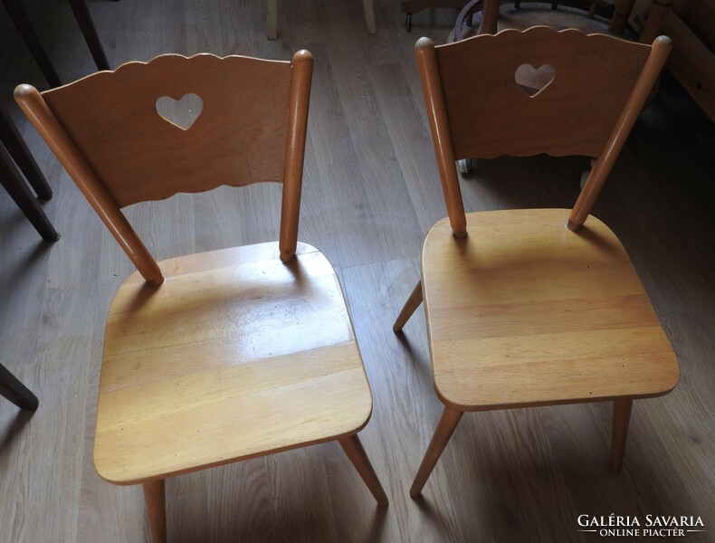 Old wooden children's small chair with heart decor on the headrest