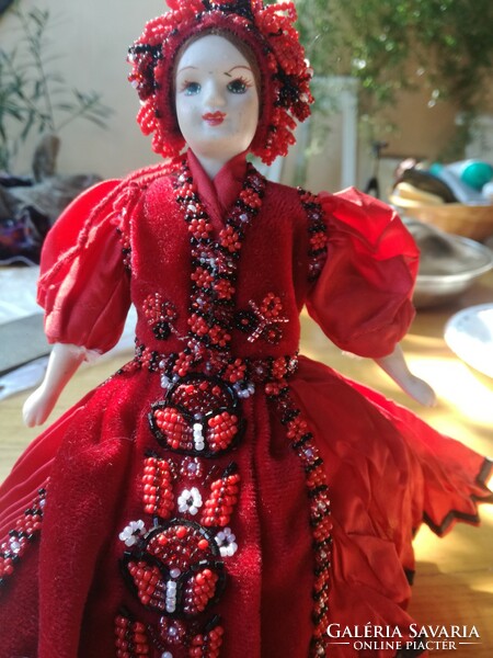 Folk costume doll, with a porcelain head, in a beaded dress