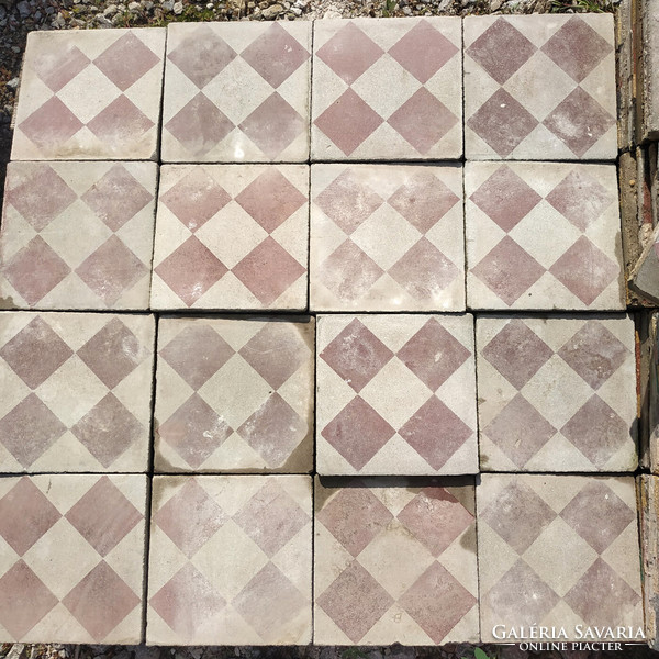 Old broken cement board with a red checkerboard pattern on a gray beige background