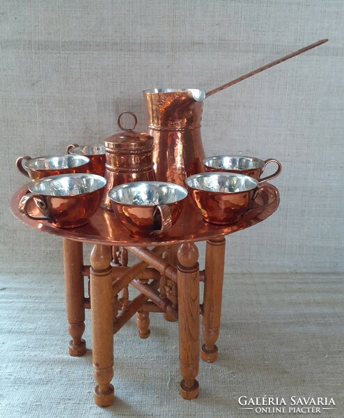 Beautiful red copper coffee set in mint condition on a folding decorative wooden table