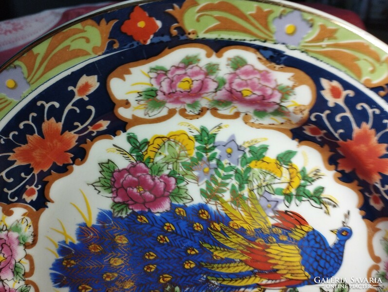 A beautiful porcelain decorative plate with a peacock pattern