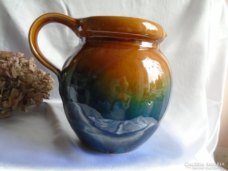 Gradient blue-green-brown ceramic jug.