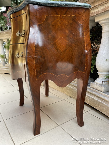 A small dresser with a marble top in a nice shape