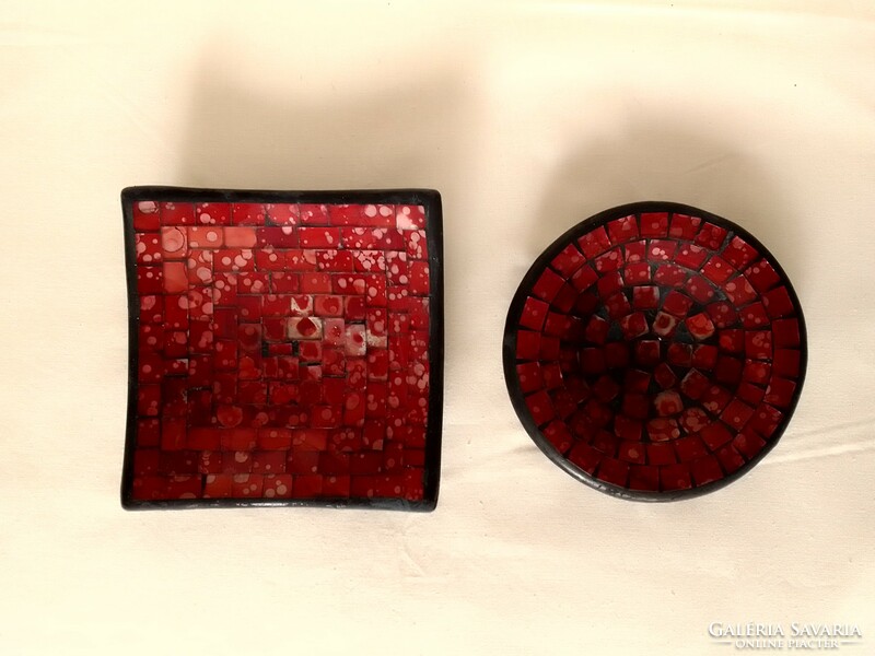 A pair of round and square glass mosaic black and red painted candle holders and candle holders on a plaster base