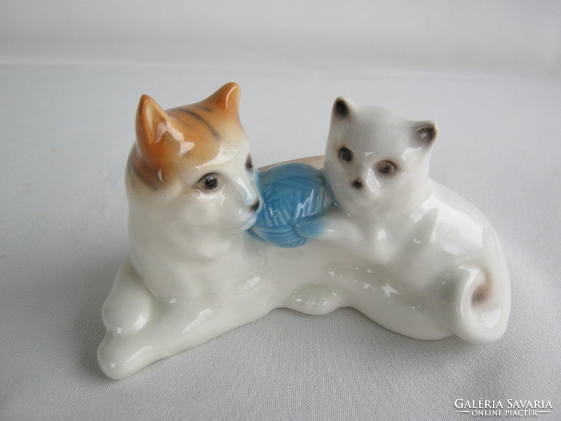 Porcelán gombolyaggal játszó cica macska