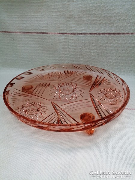 Salmon-colored, table-top, round, glass bowl with 3 small legs. An attractive cake plate.