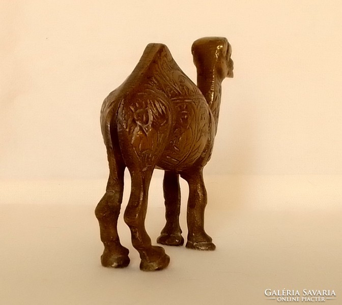 Old copper one-humped camel dromedary animal figure statue with carved pattern on the side of Arabian African desert